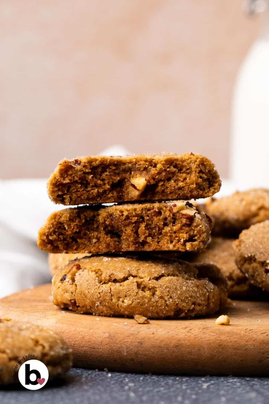A stack of two pecan brown sugar cookies with one cut in half to reveal the chewy center.