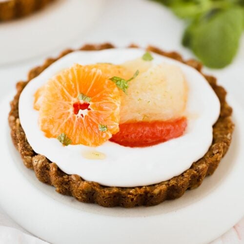Cream mini tart with winter citrus on a plate