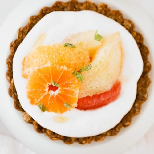 Top of a mini tart with cream and winter citrus.