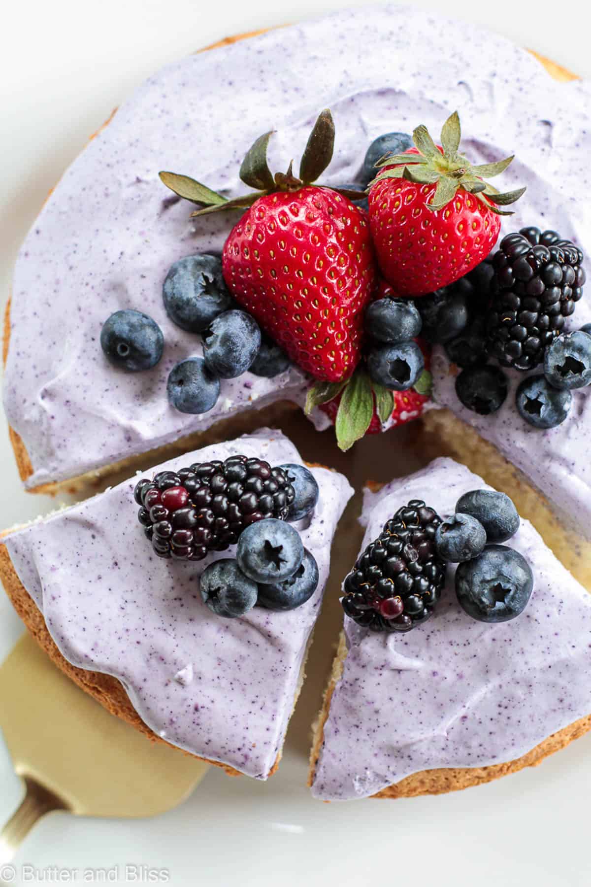 Top view of a mini angel food cake topped with blueberry whipped cream and fresh fruit for spring