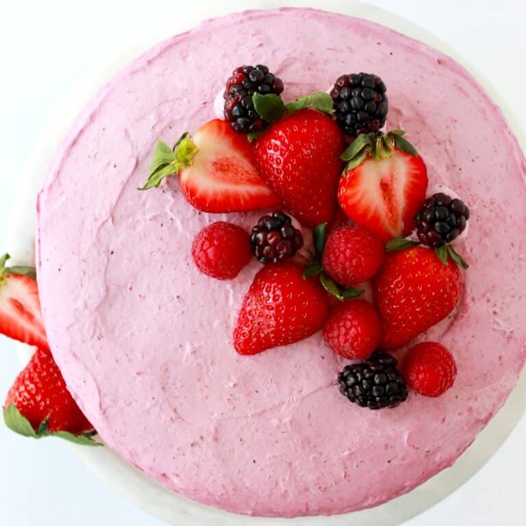 Top view of a berry mousse cake on a white cake platter