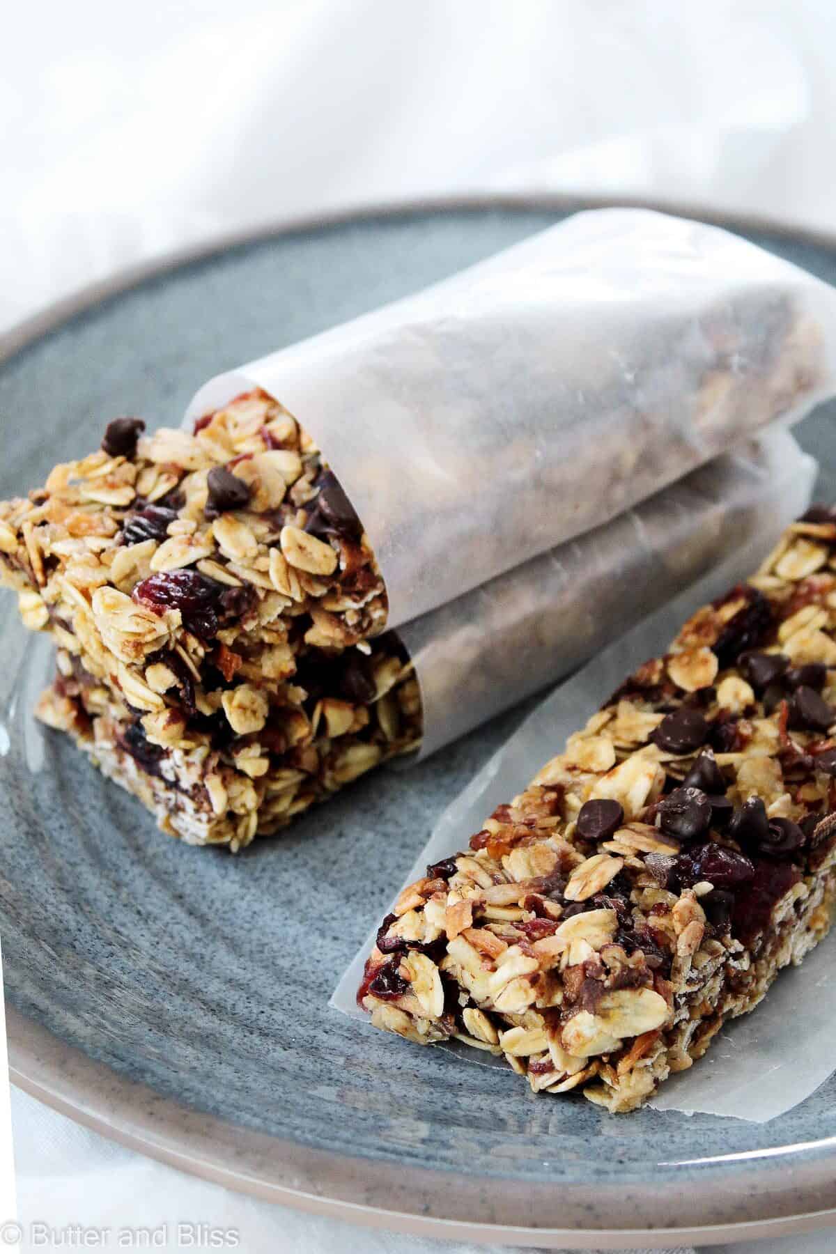 Cranberry and chocolate granola bars stacked on a blue plate