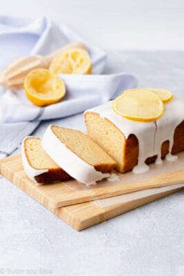 Slices of gluten free lemon loaf with icing on wood cutting board