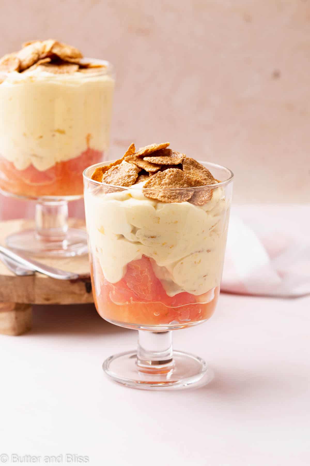 Delicious and creamy mango cream spring dessert in a parfait glass layered with grapefruit and cornflakes
