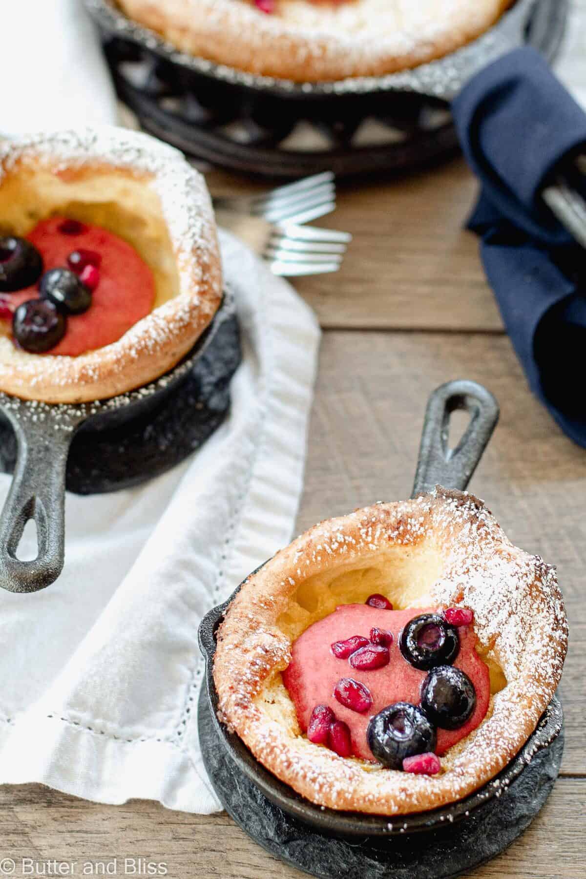 Mini dutch baby pancakes with cherry curd filling on a table