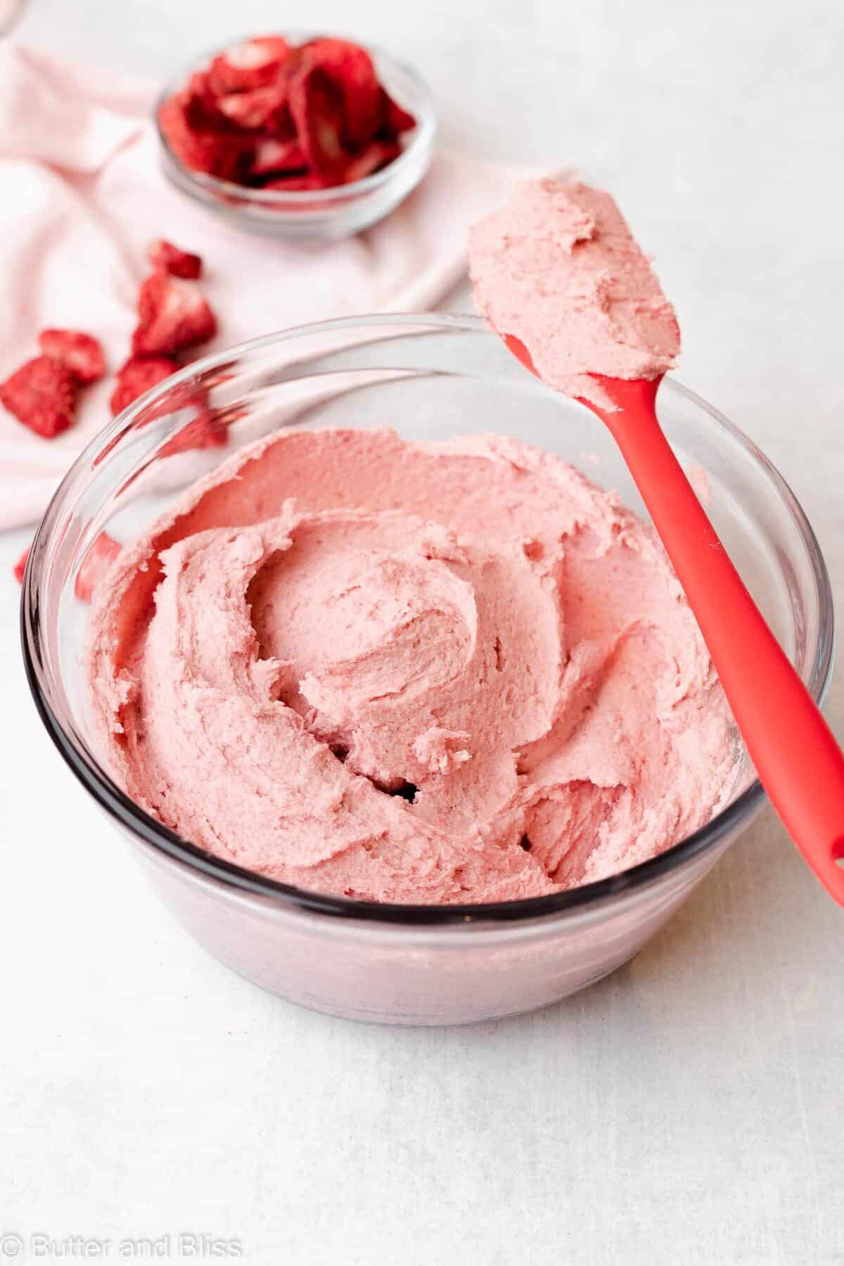 Inside view of a bowl of strawberry butter free frosting with a spatula