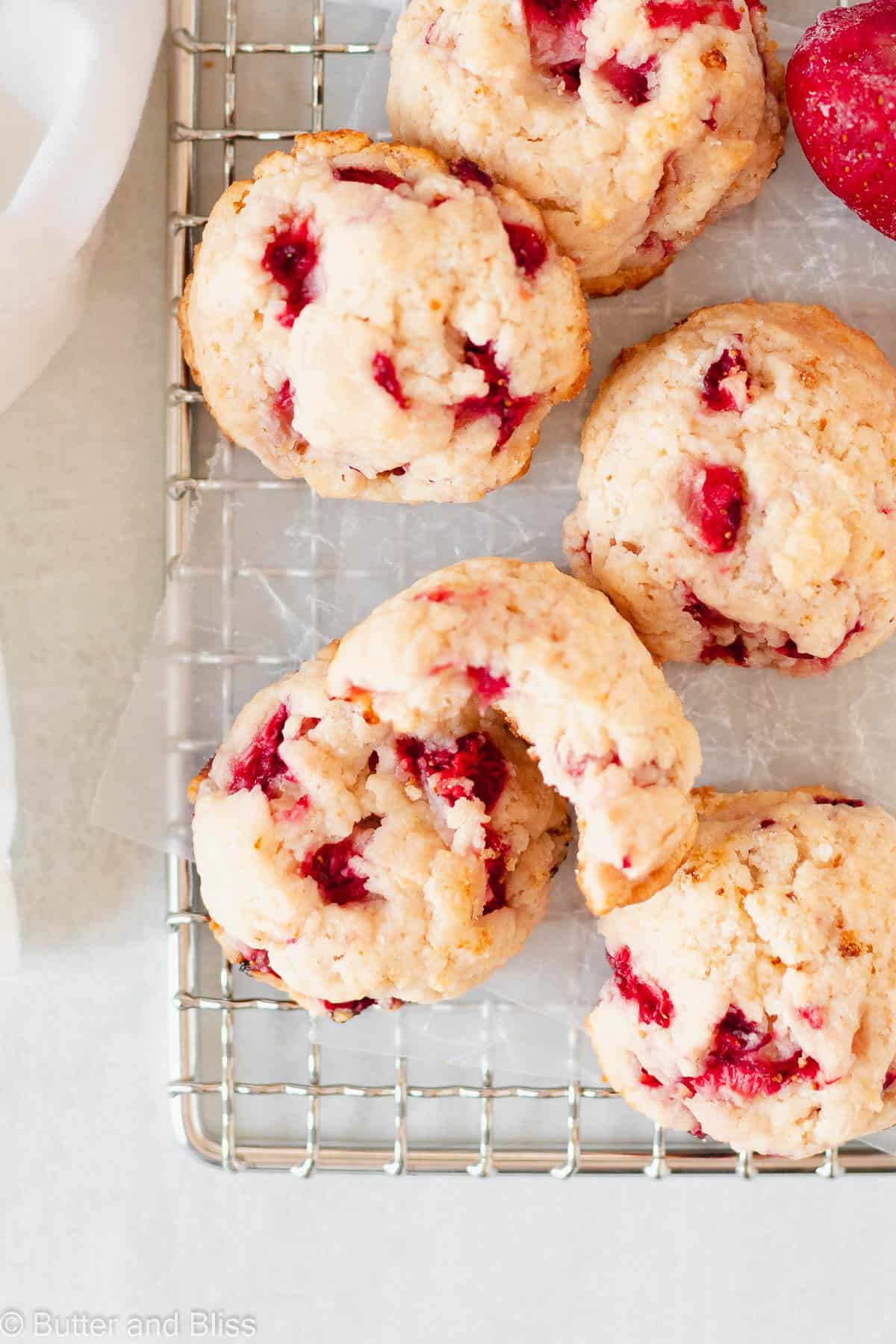 Strawberry shortcake biscuit cookies arranged on a wire cooling rack