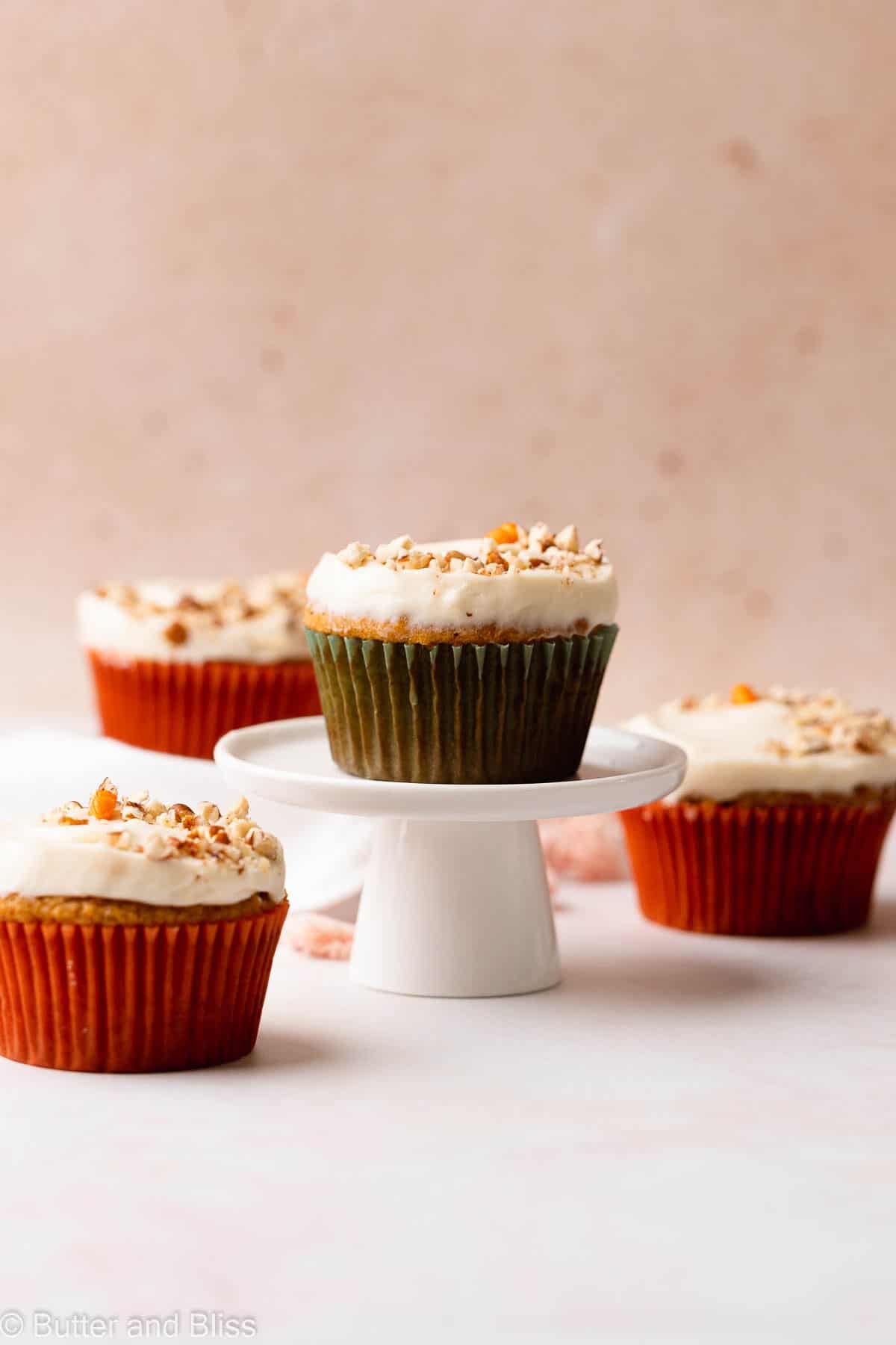 Carrot cake cupcake with cream cheese frosting on a mini cupcake stand