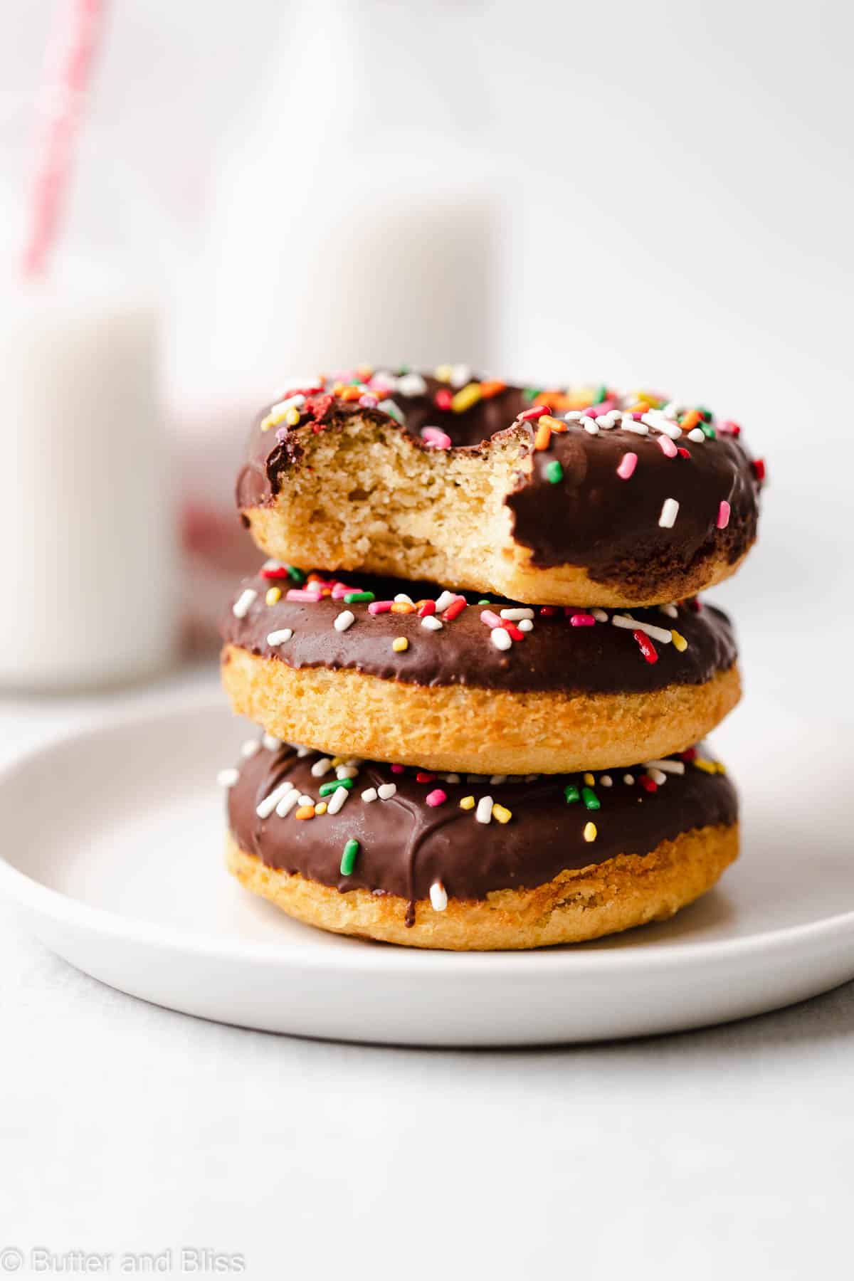 Bite shot of a gluten free vanilla donut with chocolate glaze