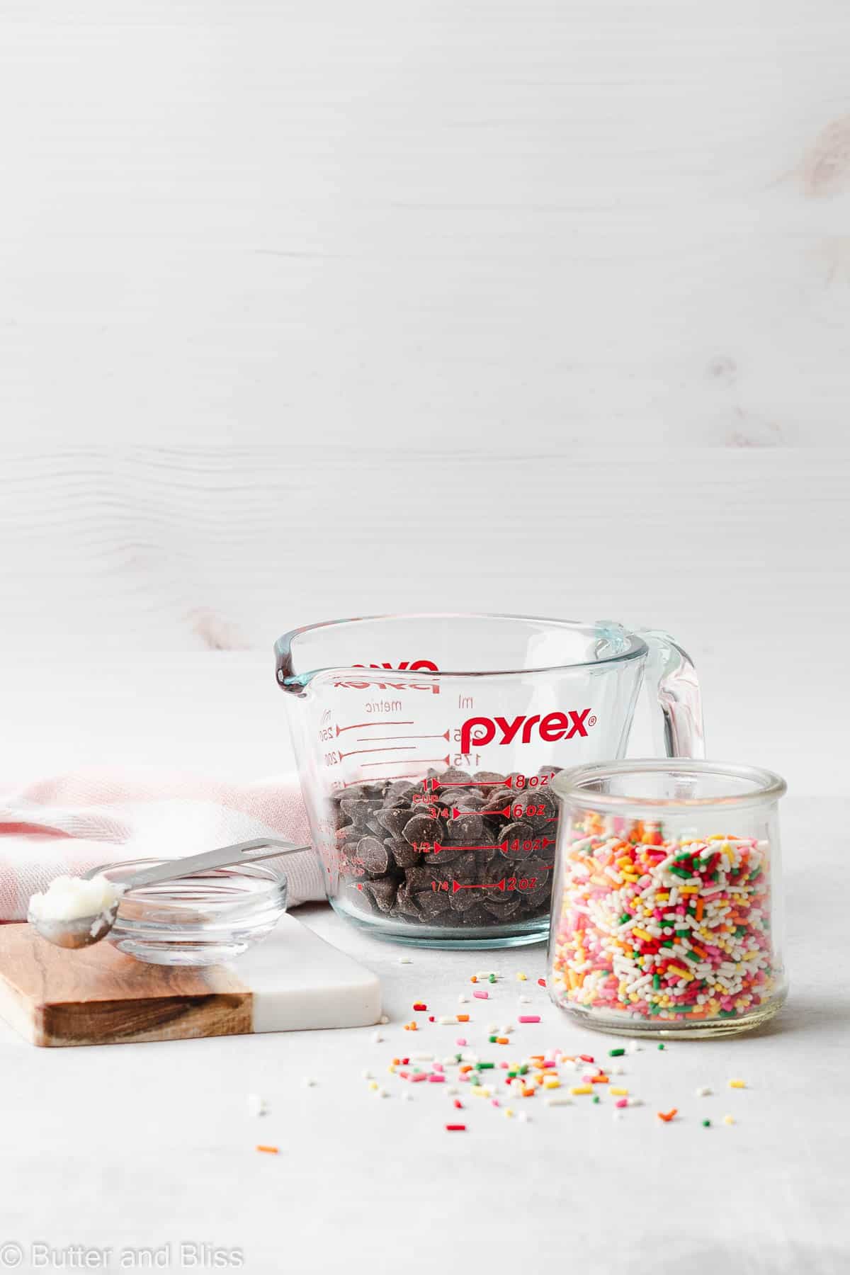 Chocolate chips and sprinkles in jars on a table