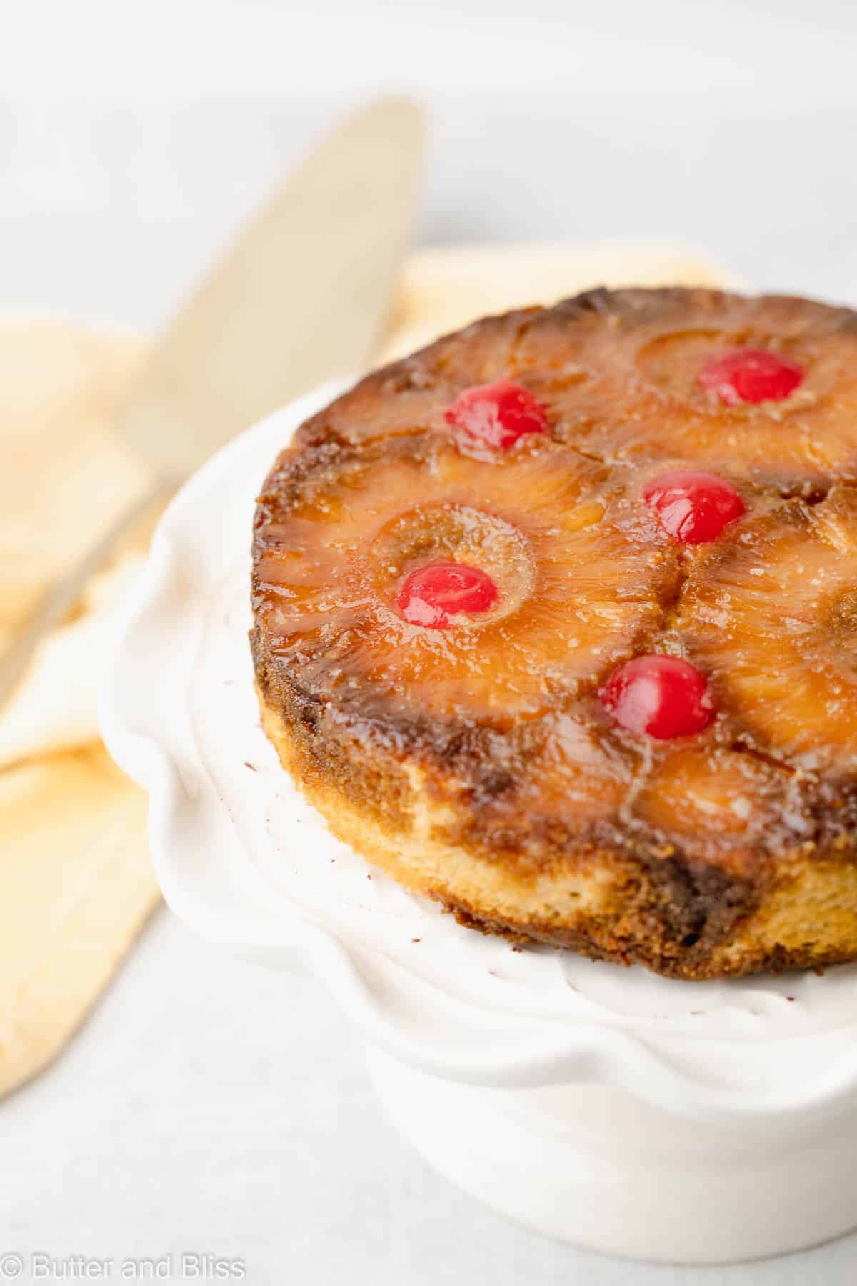 Close up of a mini gluten free pineapple upside down cake on a cake platter