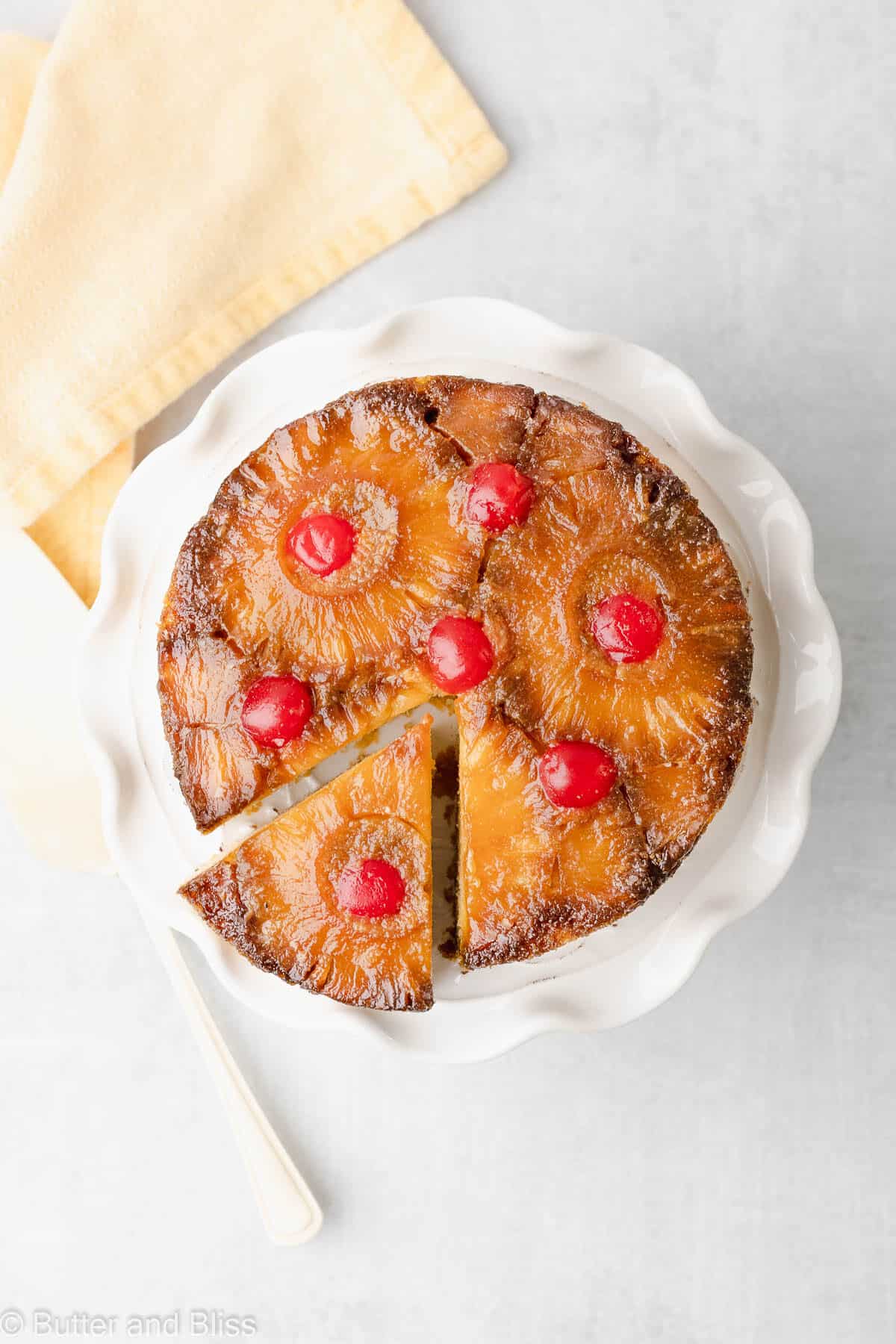 Top view of a mini pineapple upside down cake with a slice cut