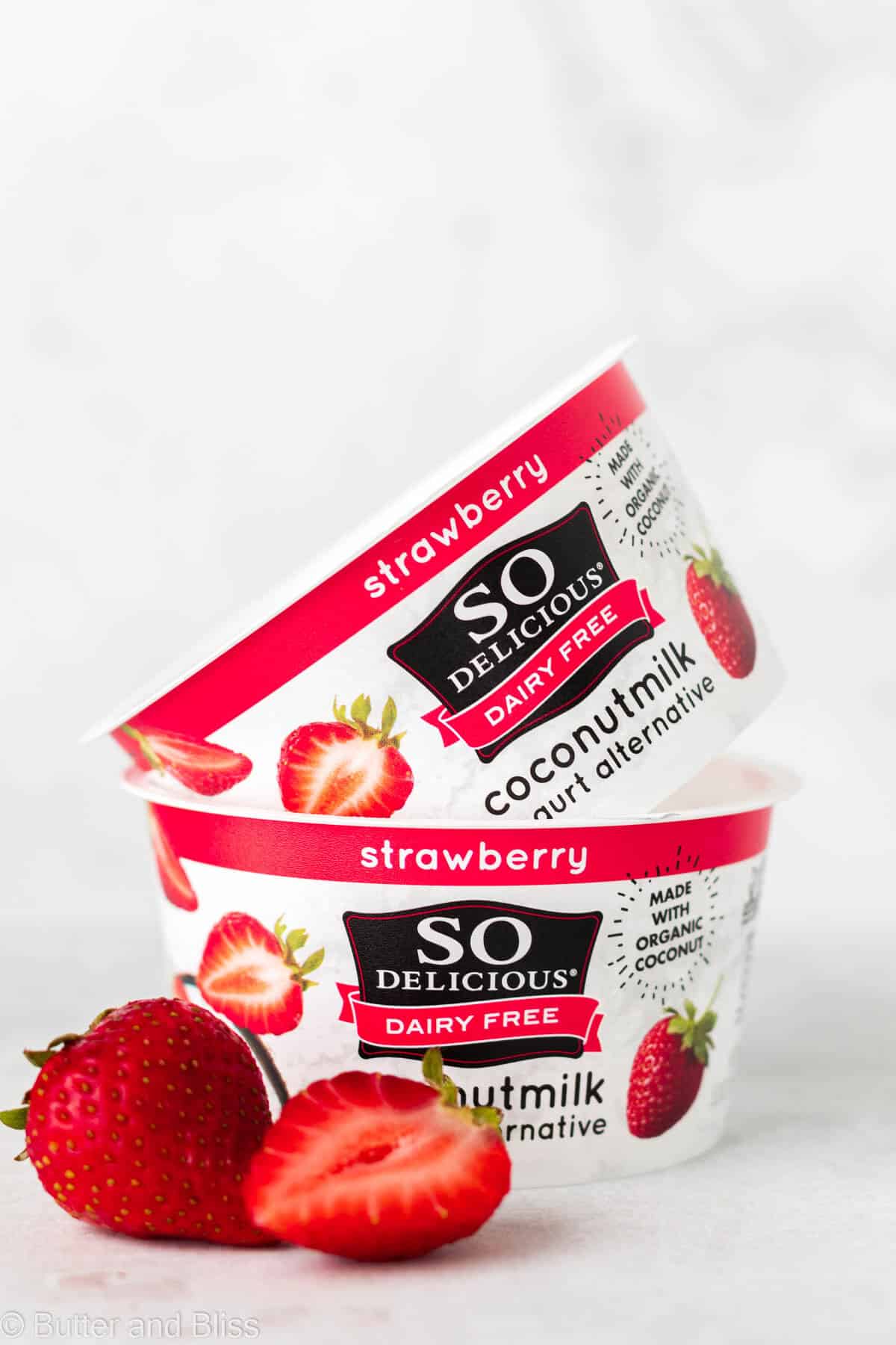 Strawberry coconut milk yogurt containers on a table.