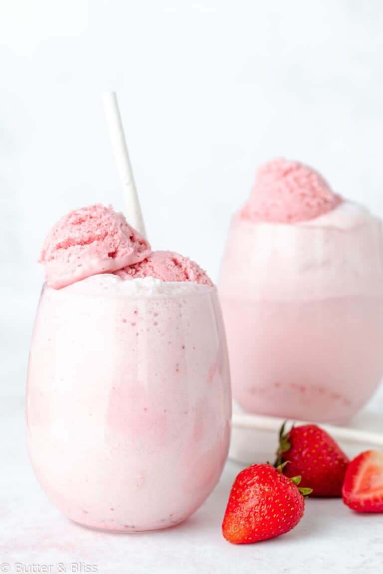 Two strawberry floats in glasses onw a white table