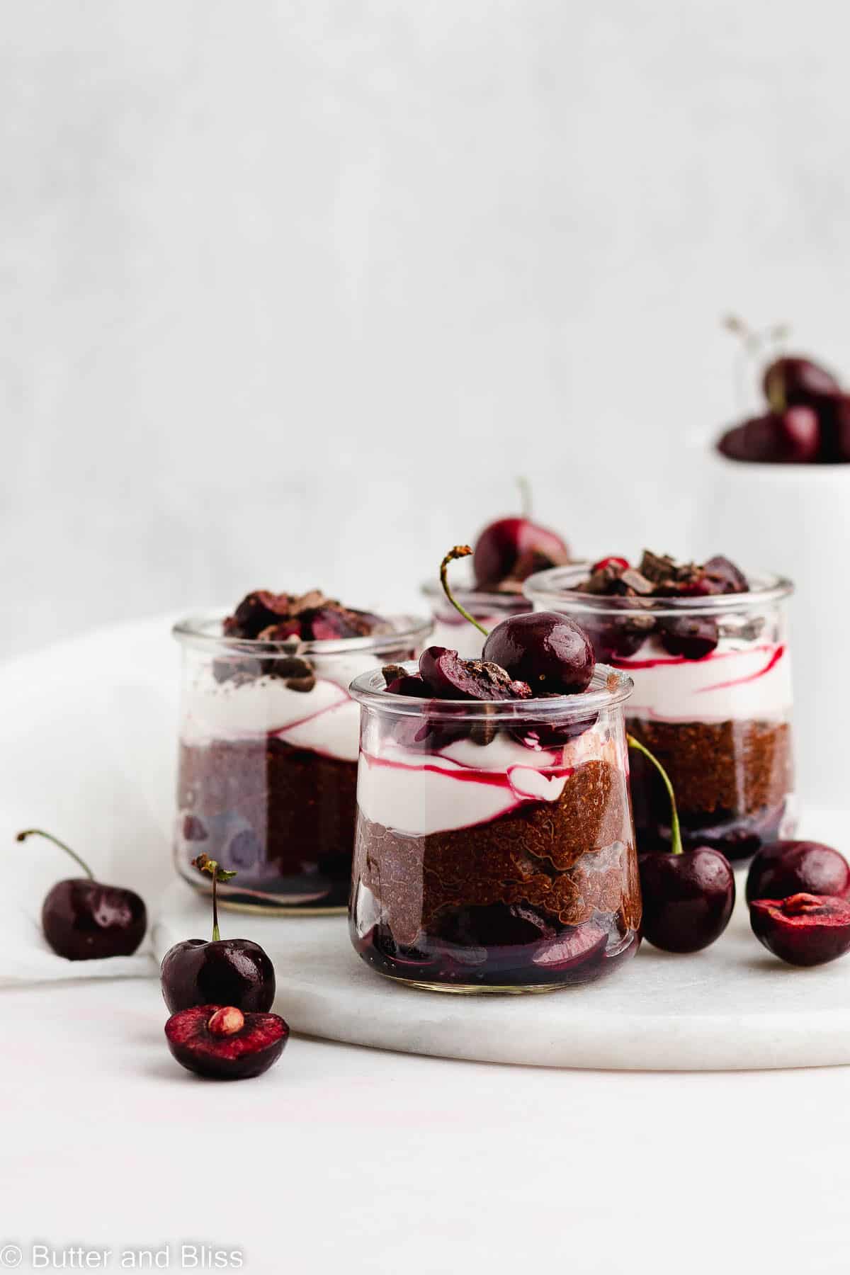 Mini black forest chia pudding parfaits on a serving platter on a table
