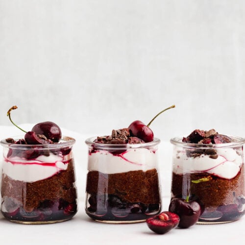 Row of three black forest chia pudding parfaits set on a table
