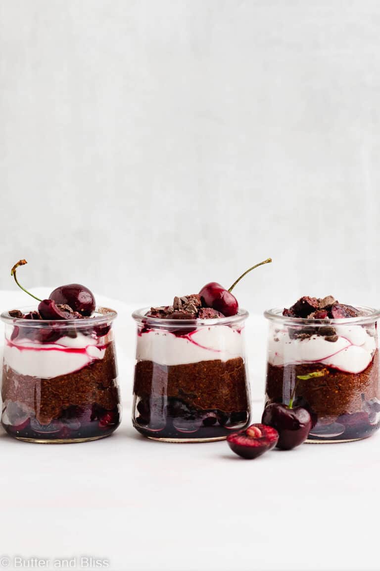 Row of three black forest chia pudding parfaits set on a table
