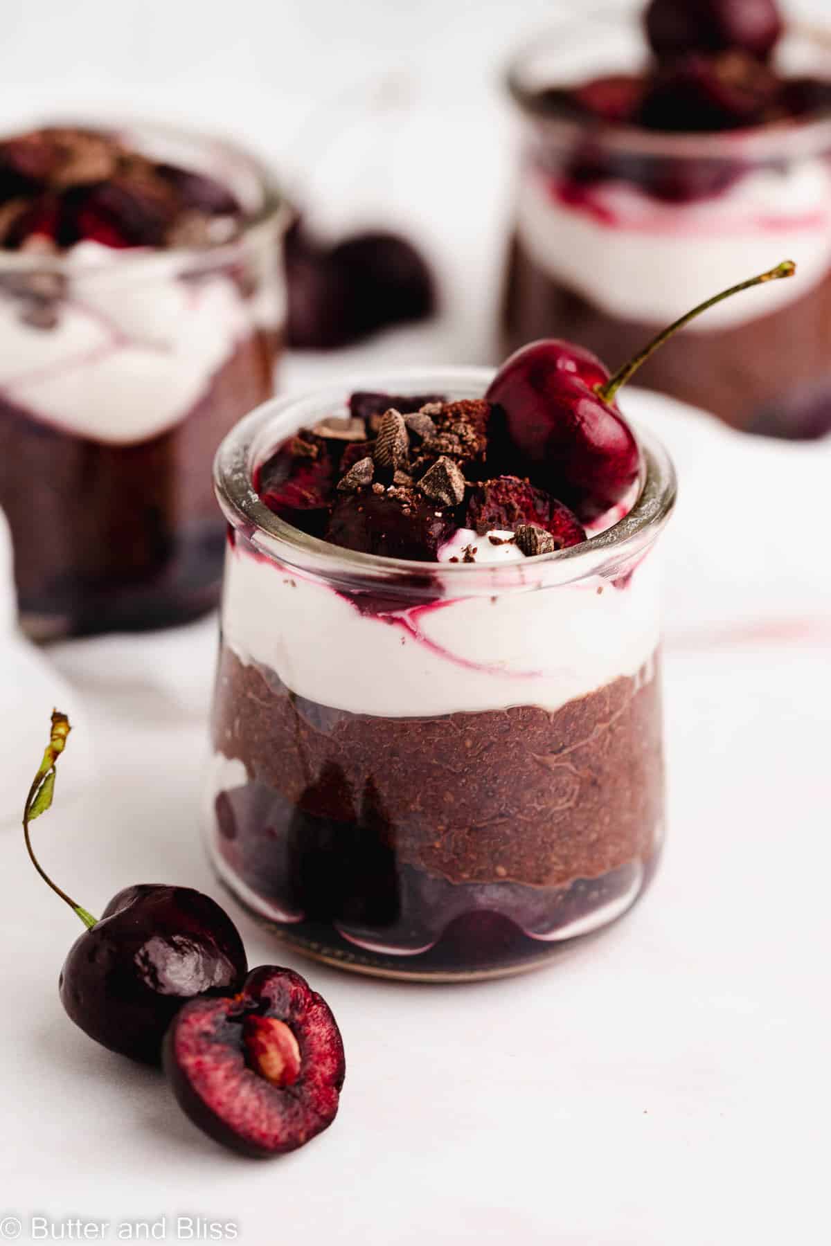 Black forest chia seed pudding in small glasses arranged on a table