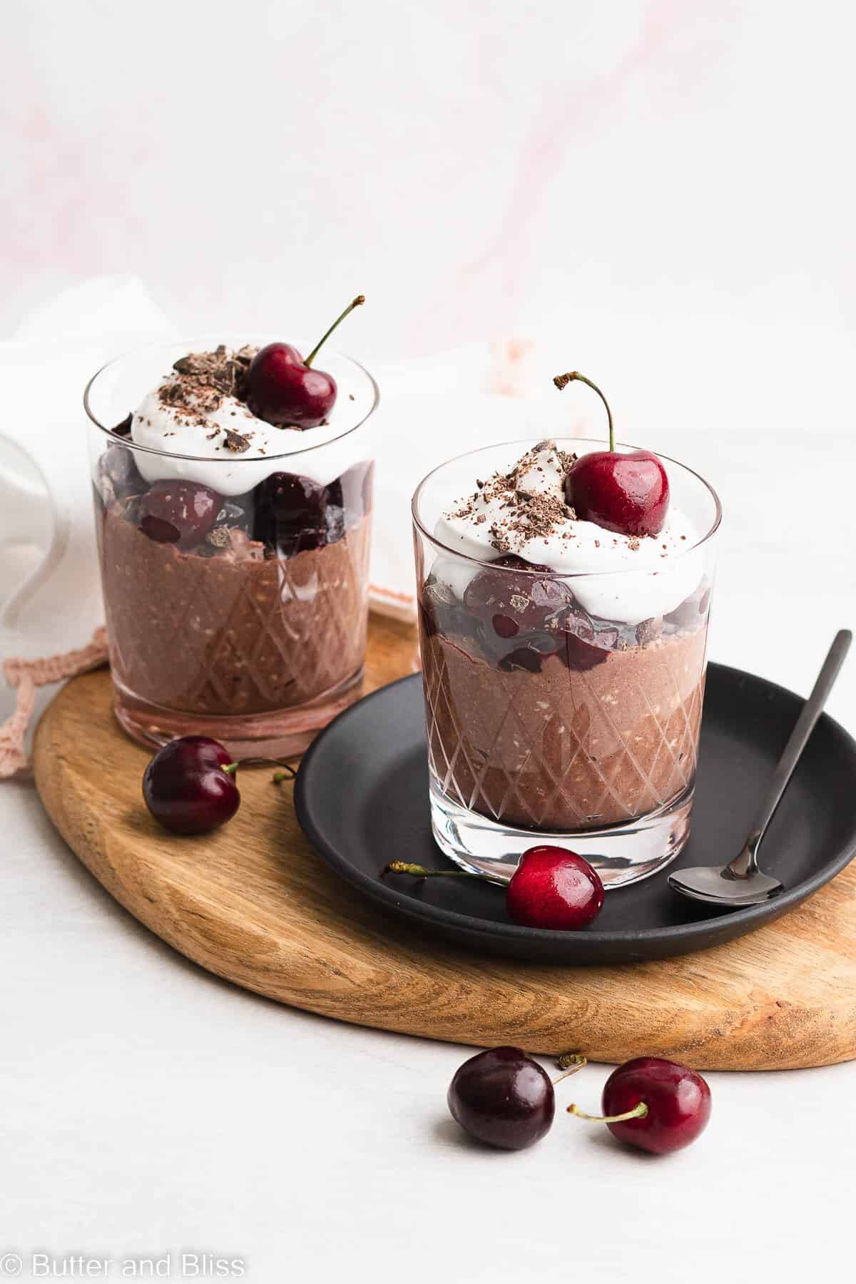 Two servings of black forest overnight oats on a wood tray