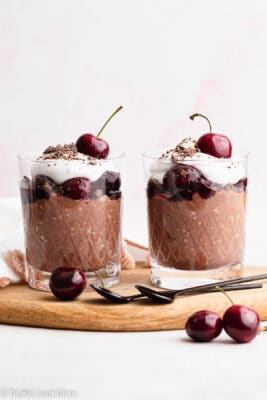 Two servings side by side on a wood tray of black forest overnight oats