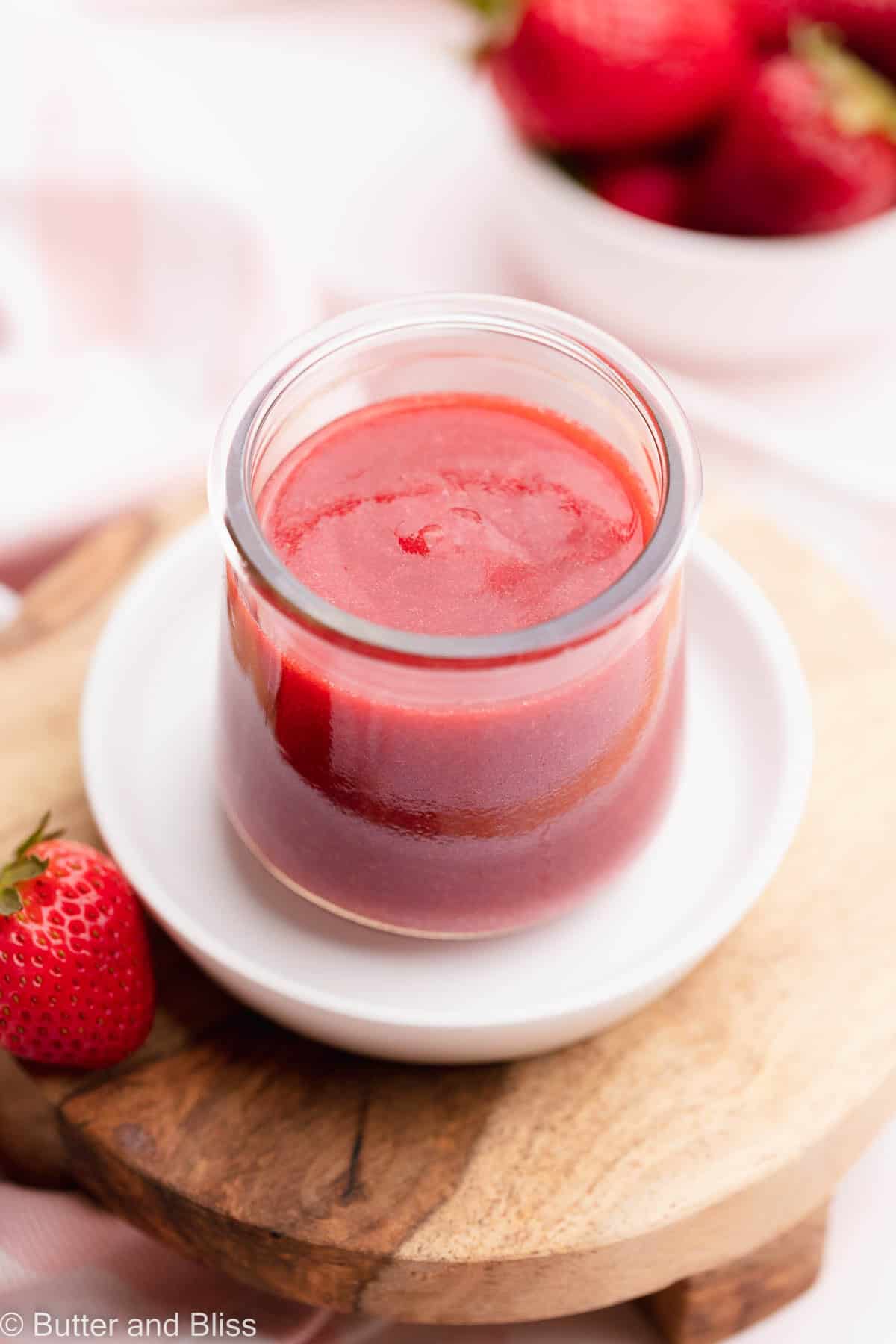 Strawberry sauce in a jar on a white plate