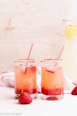 Two glasses of strawberry lemonade on a table