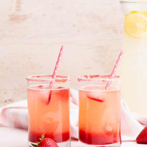 Two glasses of strawberry lemonade on a table
