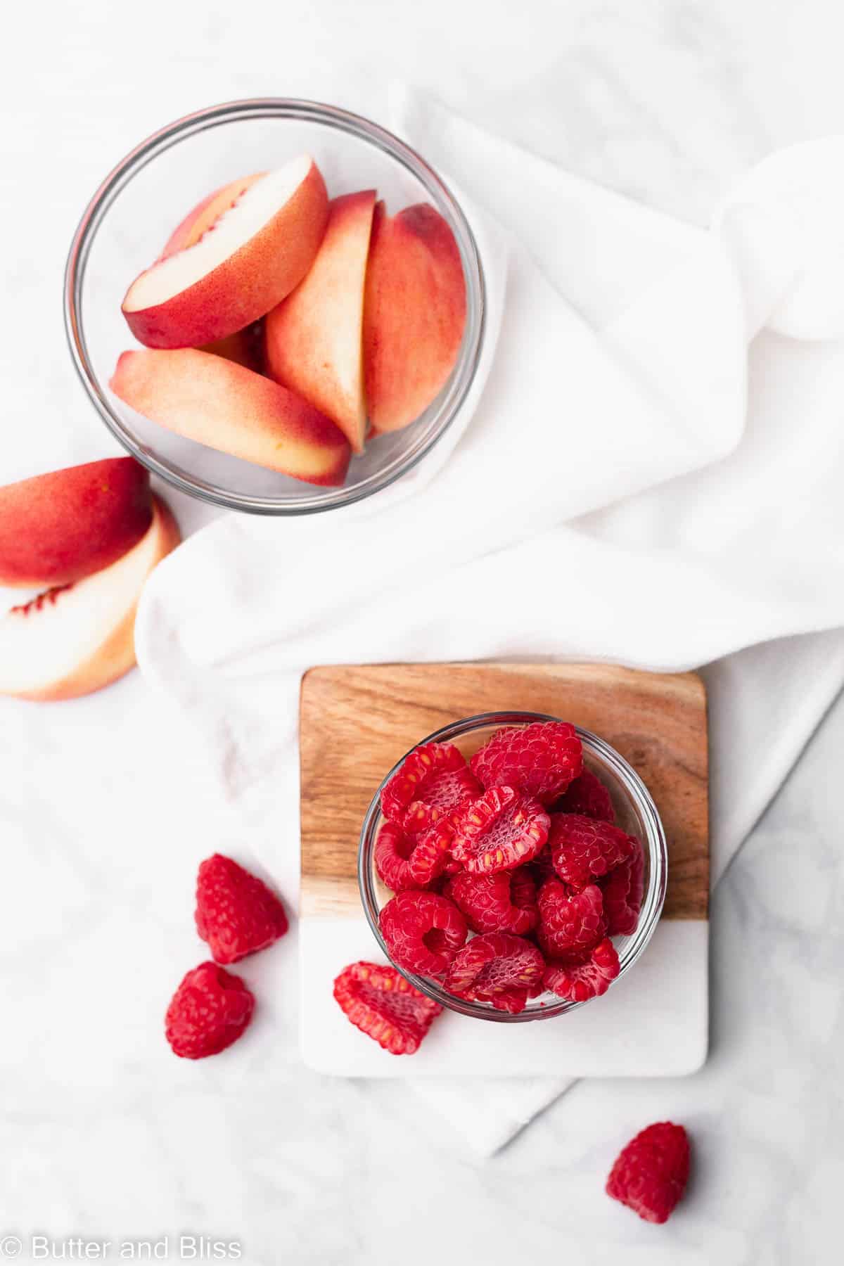 Fresh raspberries and peaches in a bowl on a table