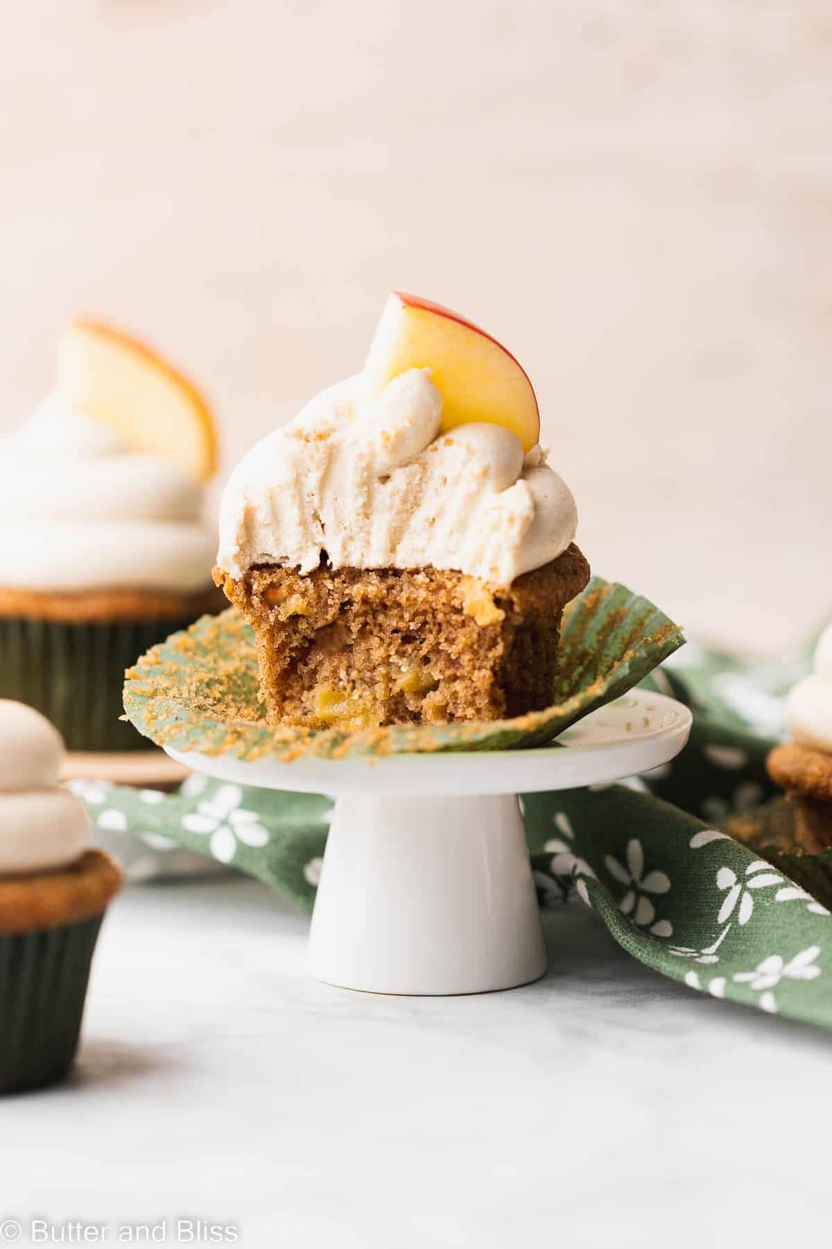 Caramel butter free frosting piped onto a cupcake sitting on a small cupcake stand.