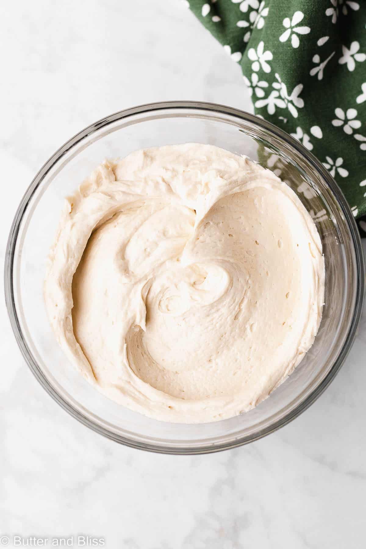 Top view of a bowl of creamy caramel frosting made without butter.