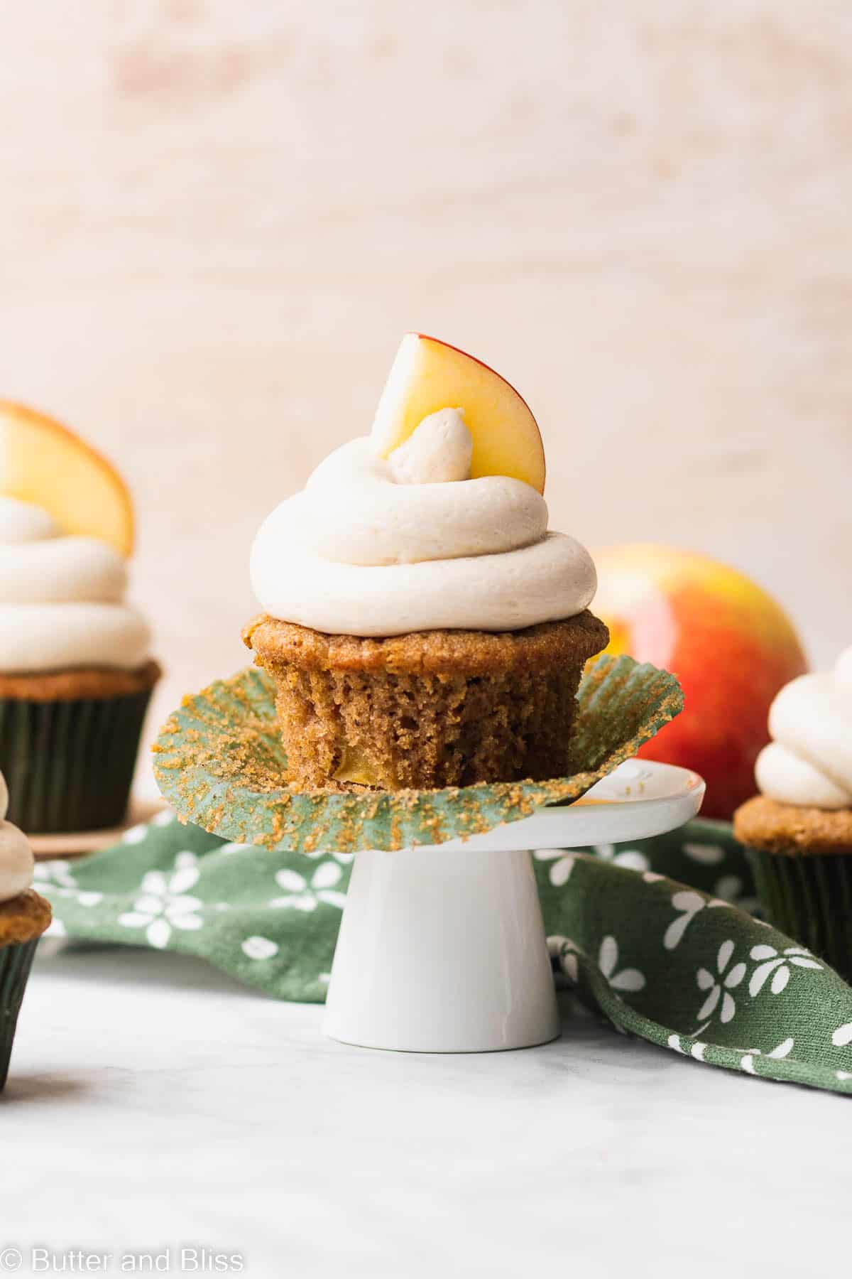 A single apple spice gluten free cupcake with the cupcake liner removed on a small cupcake stand.