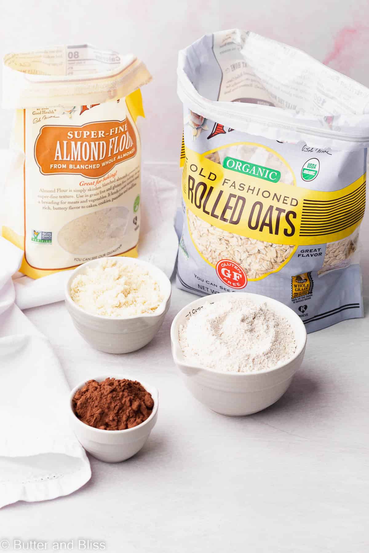 Gluten free flours in a bag on a a table with a bowl of cocoa powder.