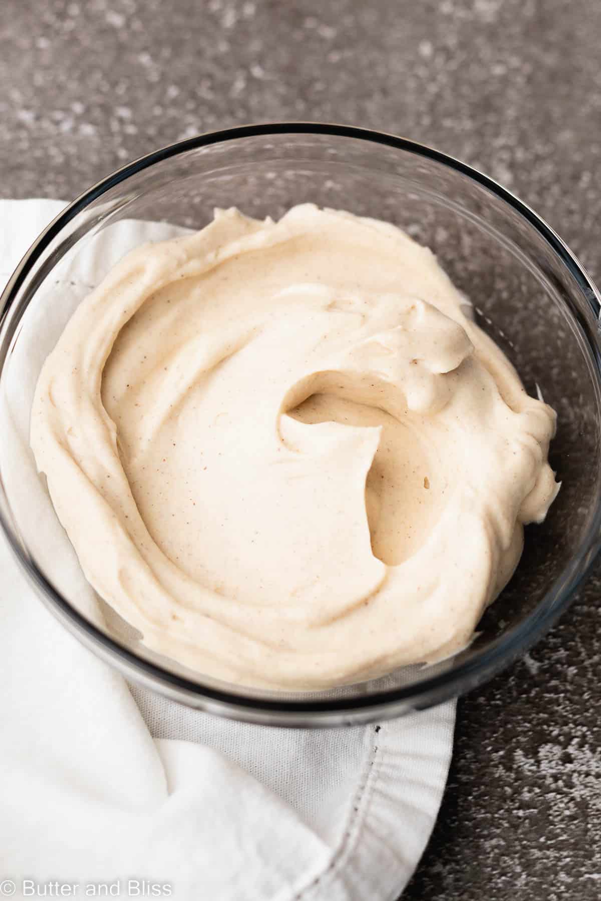 Maple cinnamon cream cheese frosting in a bowl on a table.