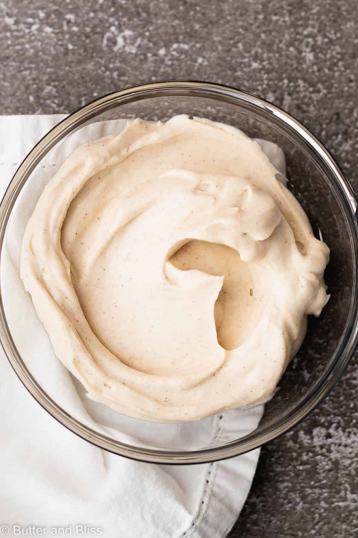 Creamy cinnamon frosting in a bowl on a table.