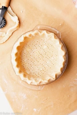 Gluten free pie crust fit and crimped in a small glass pie dish.