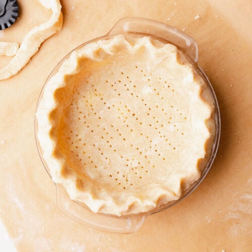 Gluten free pie crust fit and crimped in a small glass pie dish.
