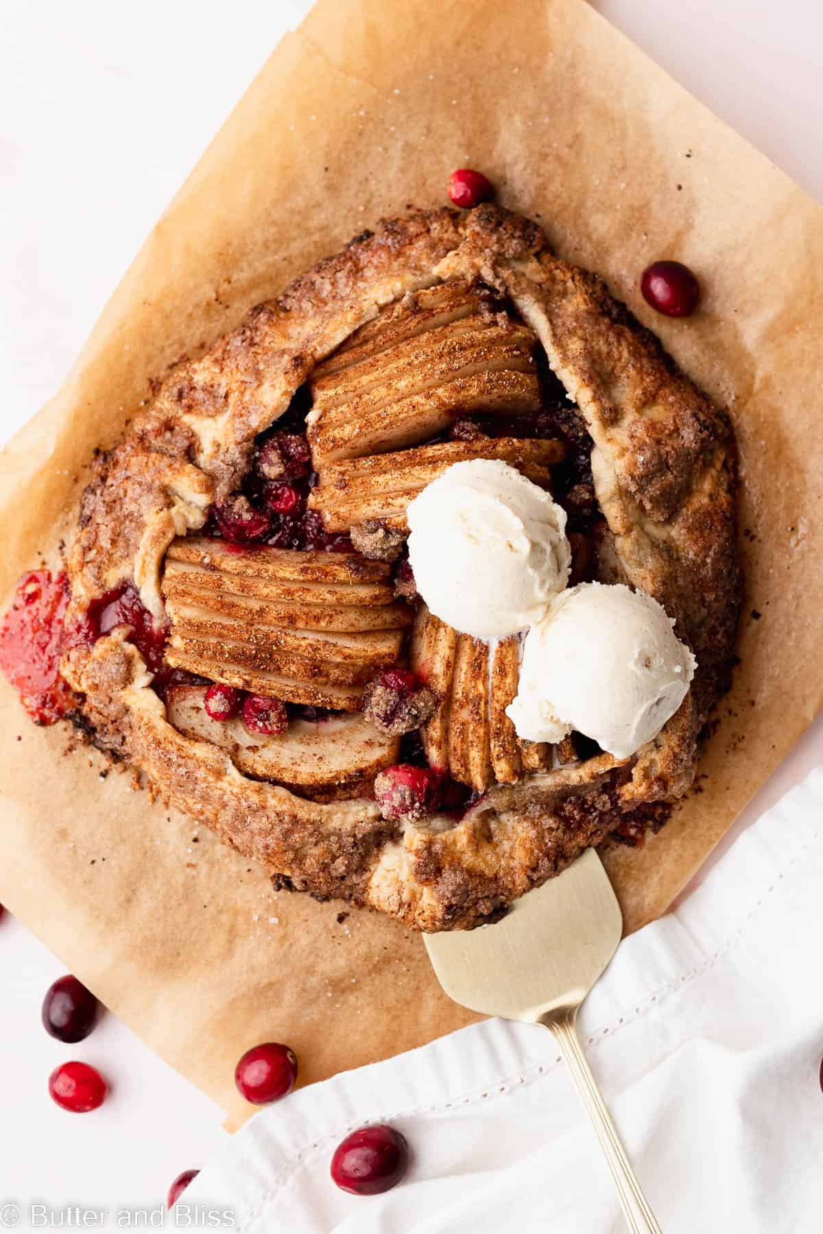 Top view of a pretty cranberry pear galette with scoops of ice cream.