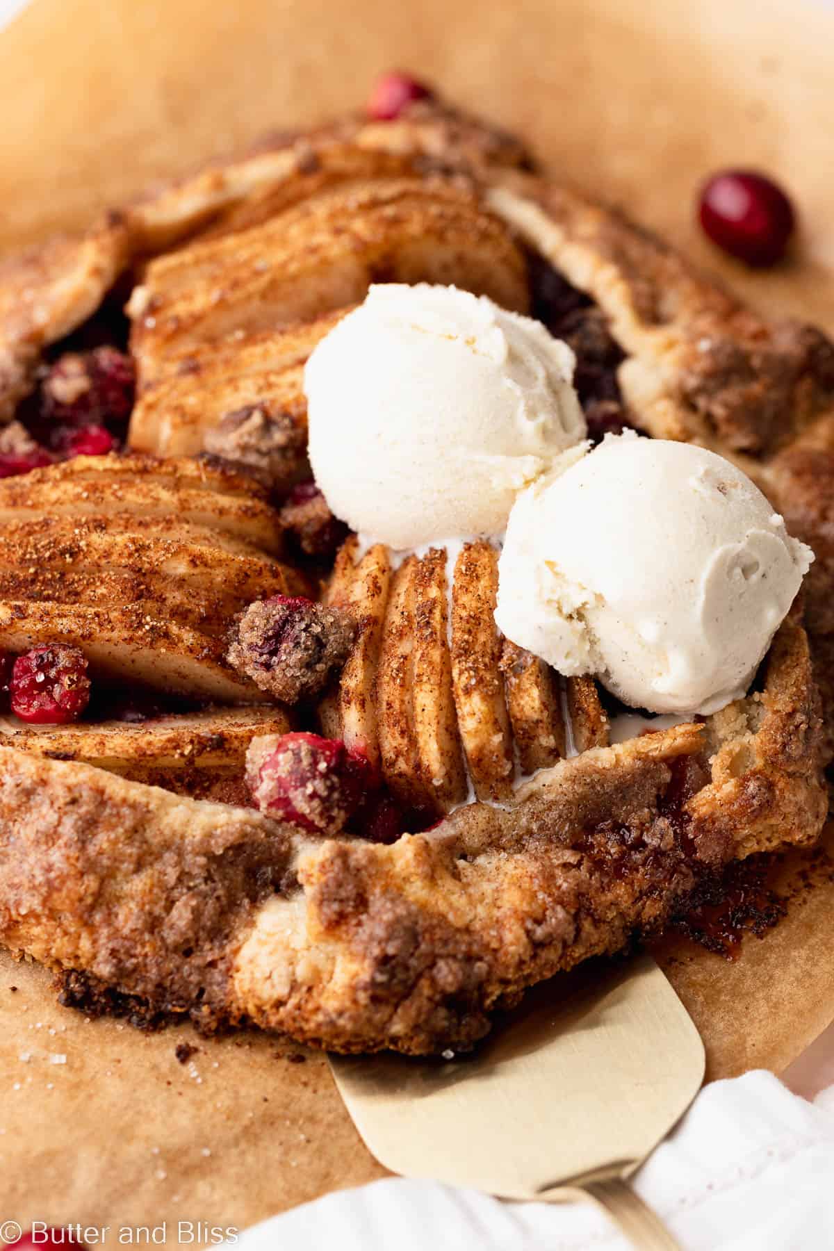 Close up of a flavorful cranberry pear gluten free galette with scoops of ice cream.