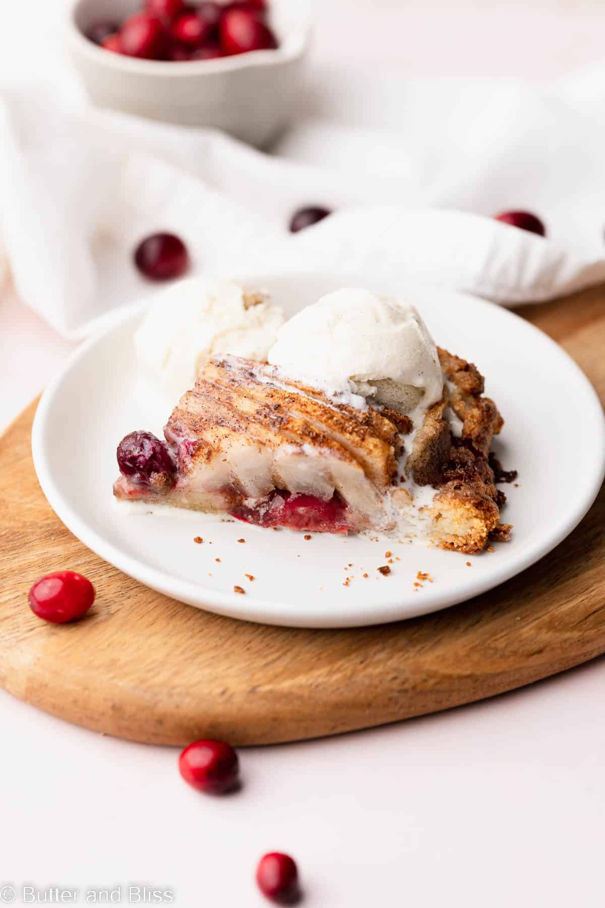 A slice of gluten free cranberry pear galette on a pretty white plate.