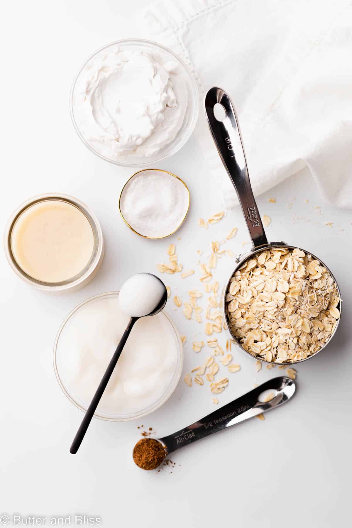 Ingredients for easy oat breakfast in small bowls arranged on a table.