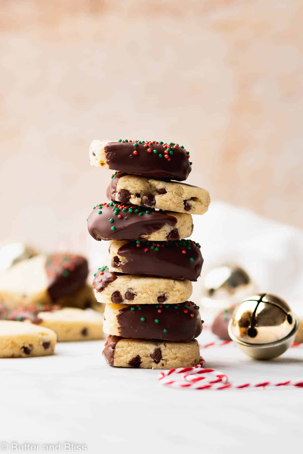 A stack of chocolate dipped chocolate chip sugar cookie bites.