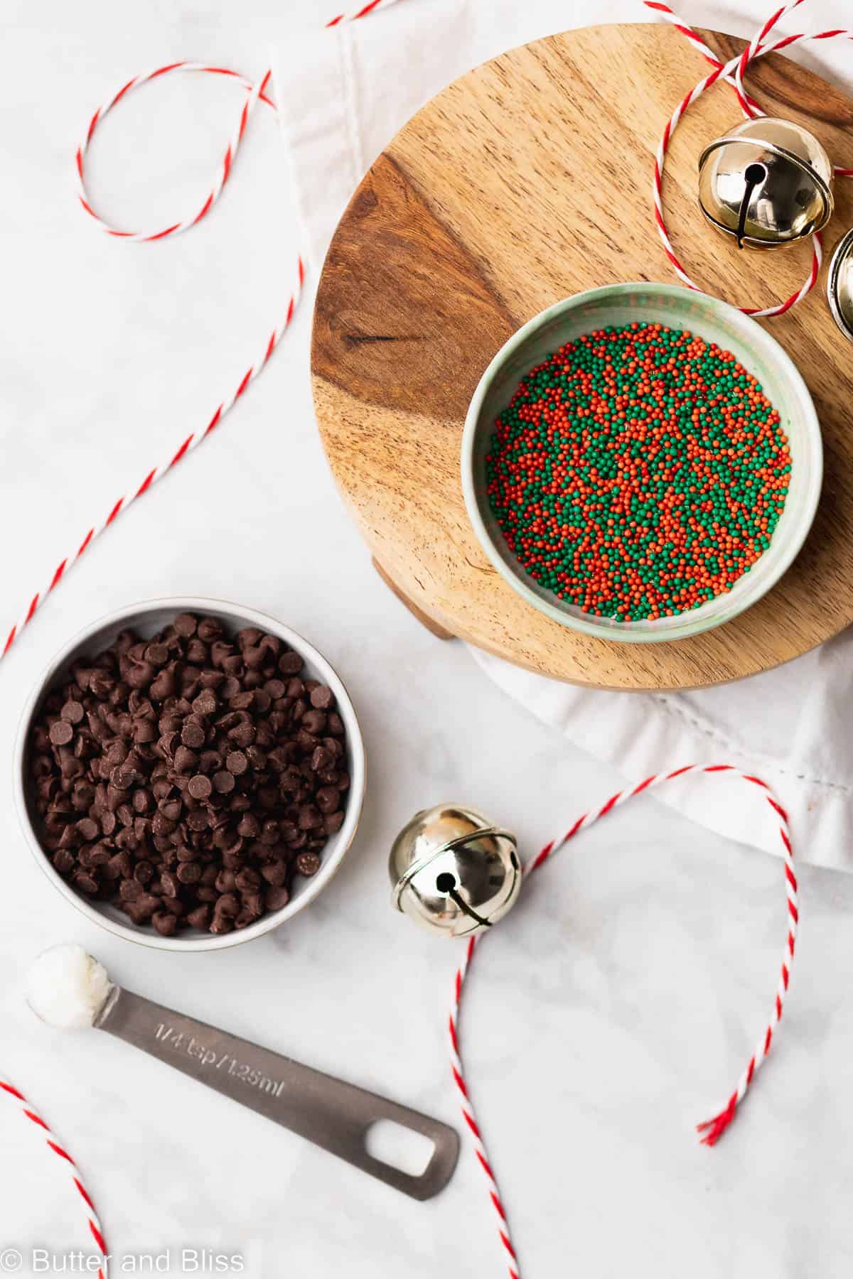 Bowls of sprinkles and chocolate chips arranged on a table.