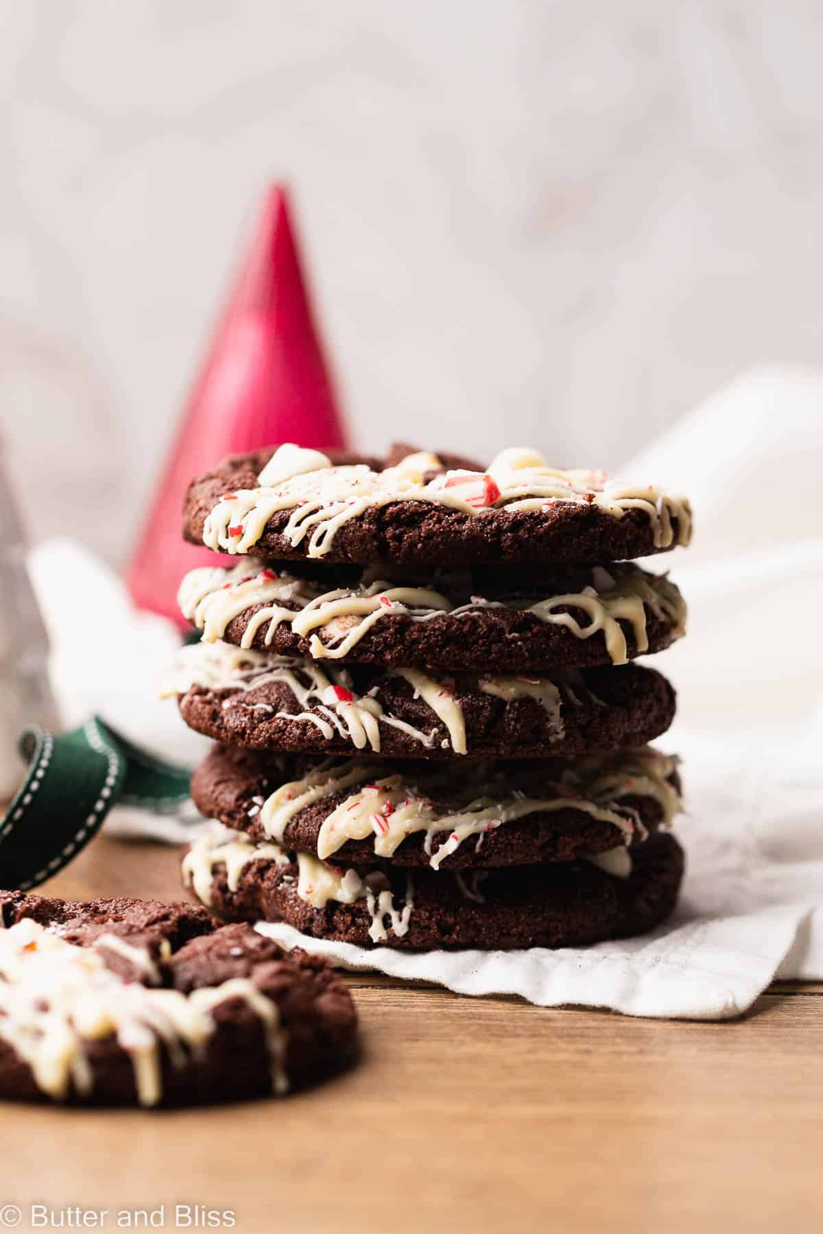 A sweet stack of gluten free white chocolate peppermint Christmas cookies on a wood table.