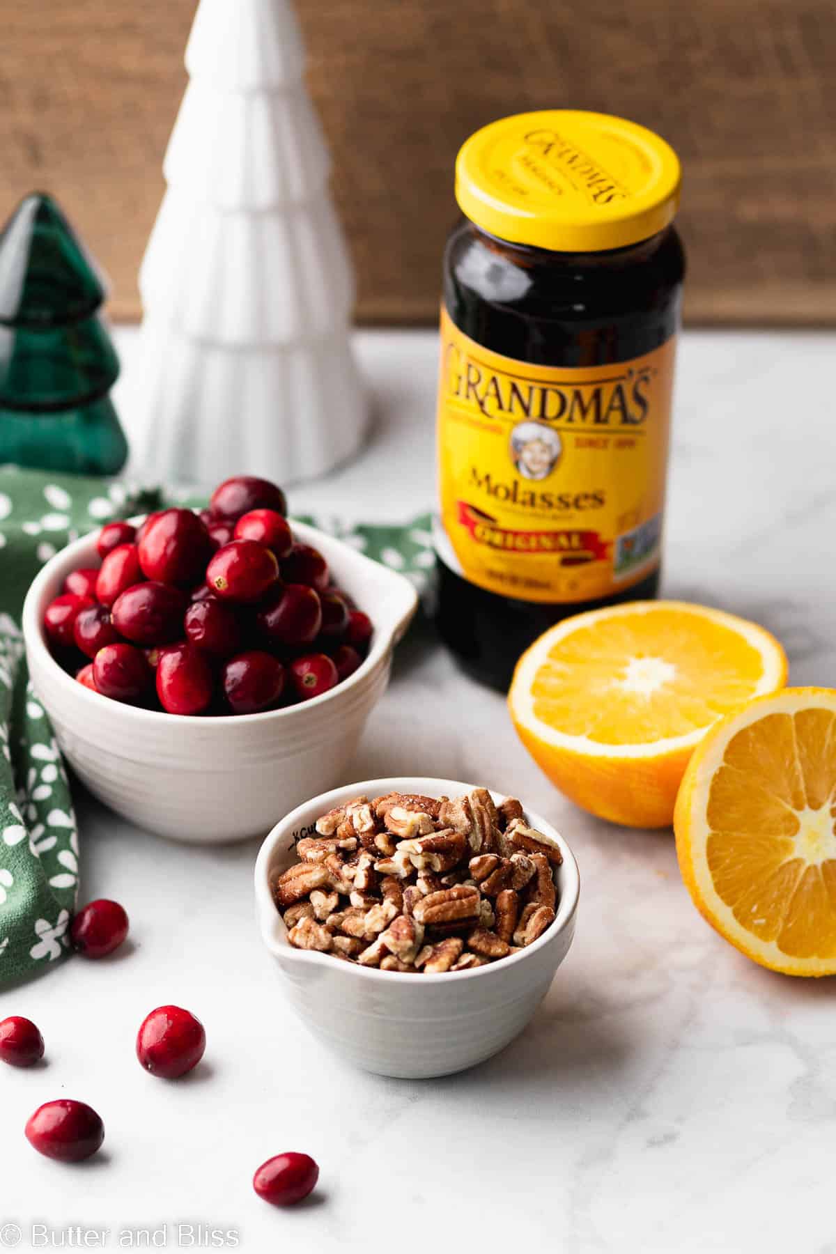 Key ingredients for cranberry Christmas bars in decorative bowls arranged on a table.