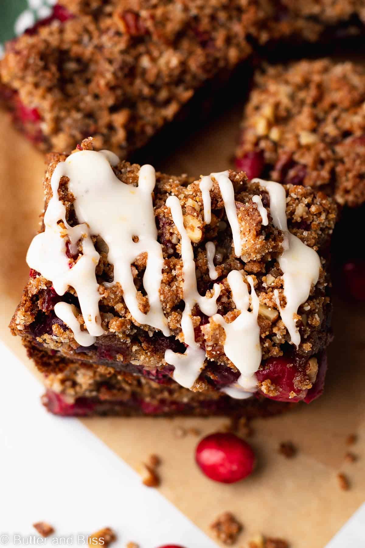 Close up of cranberry gingerbread bar with a creamy drizzle of orange icing.