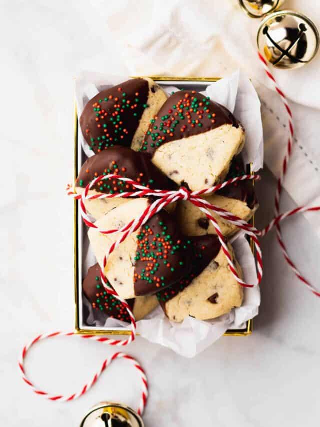 A small gift box full of chocolate dipped Christmas cookies.