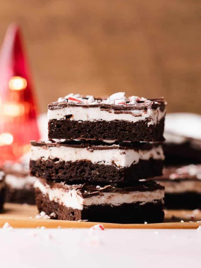 Small lopsided stack of gluten free peppermint patty brownies with candy cane sprinkles.
