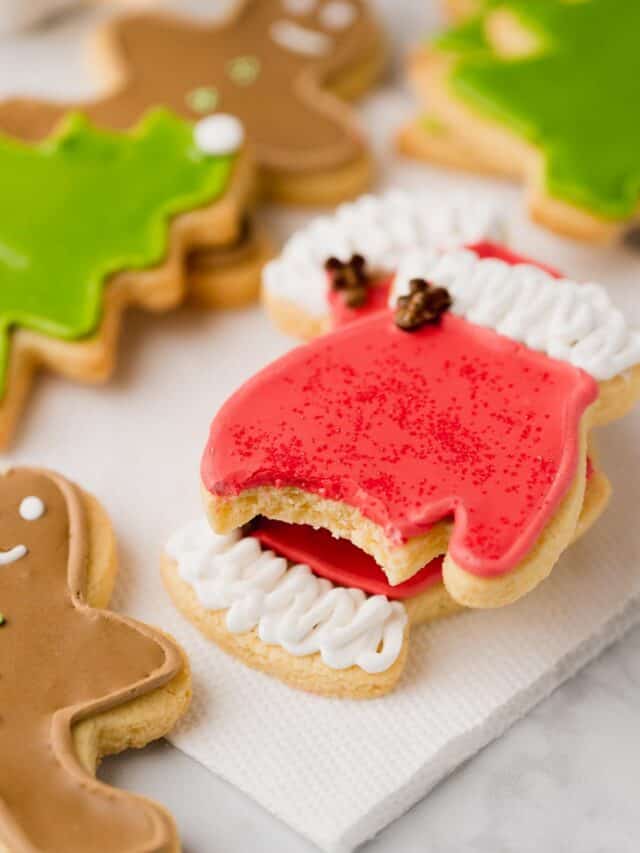 Gluten free Christmas sugar cookies frosted and arranged on a table.