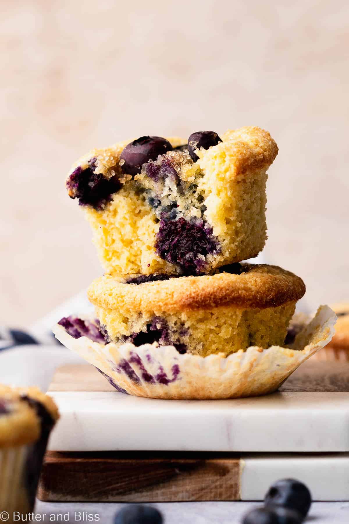 A bite shot of a fluffy gluten free blueberry muffin revealing tons of blueberries.