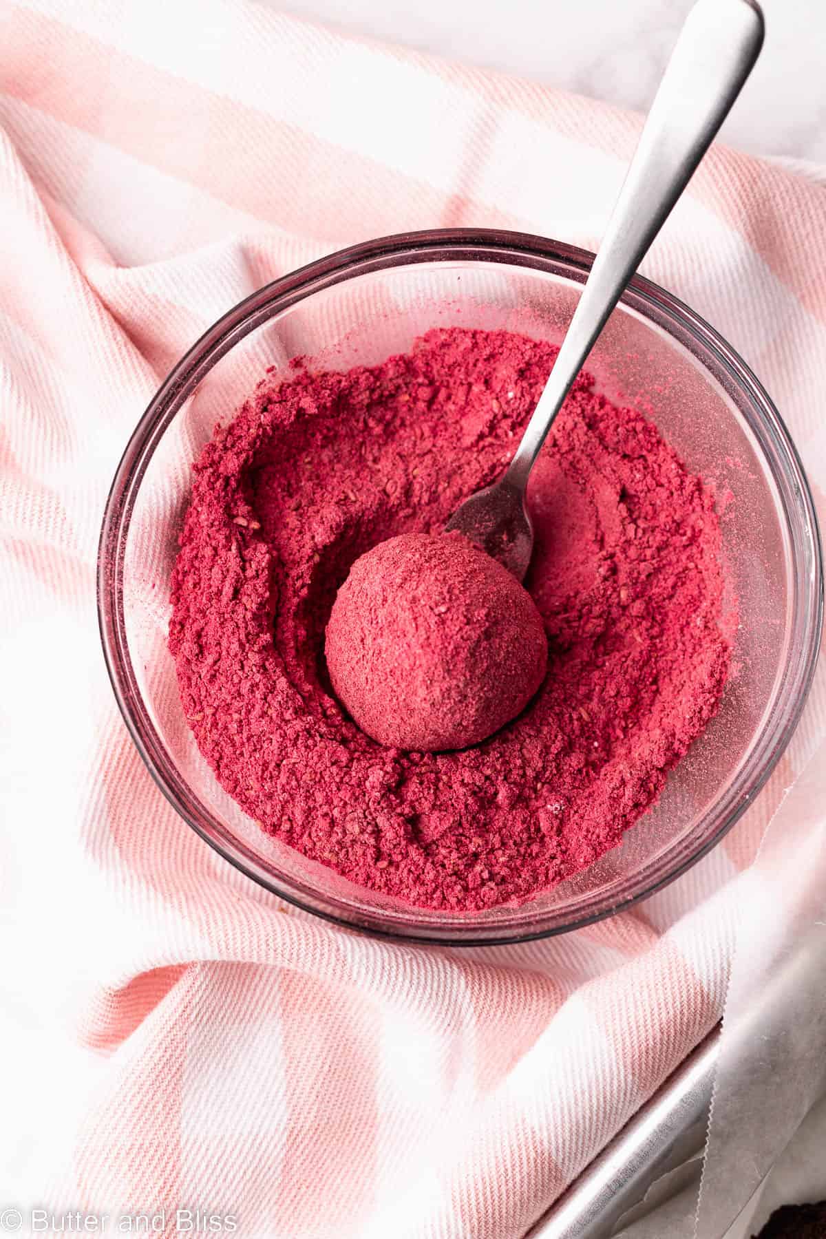 A cake bite rolled in freeze dried strawberry powder.
